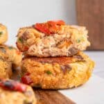 Close-up of Salmon croquettes stacked on a wooden board against a light background.