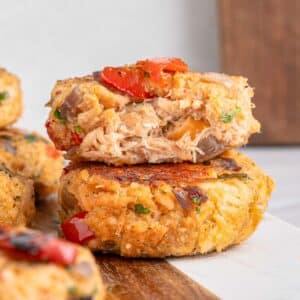 Close-up of Salmon croquettes stacked on a wooden board against a light background.