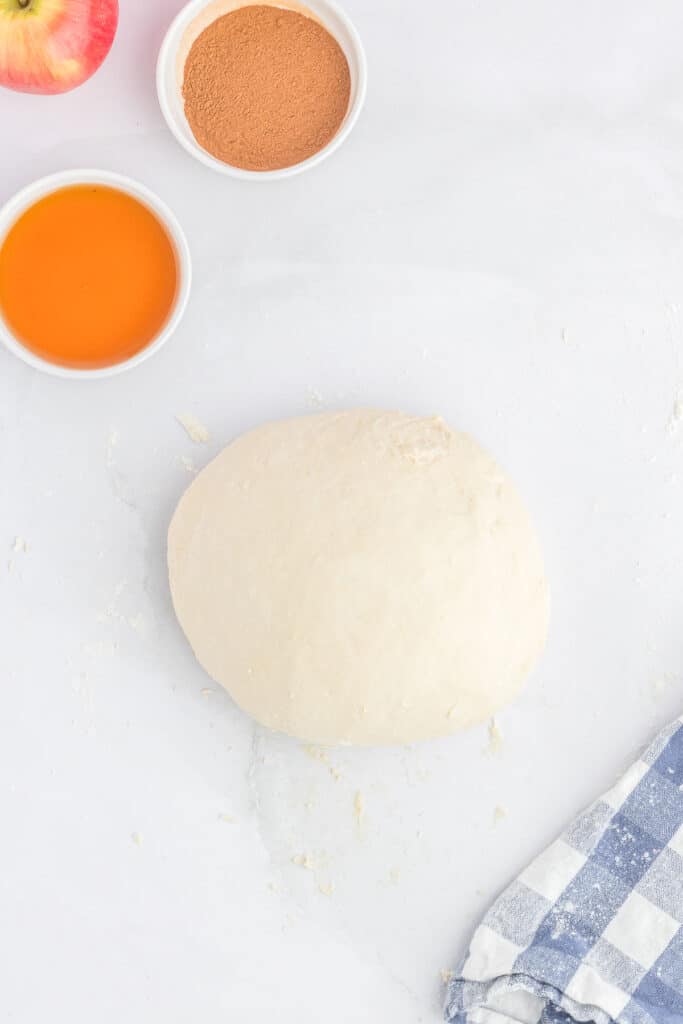 A ball of dough on a floured countertop.
