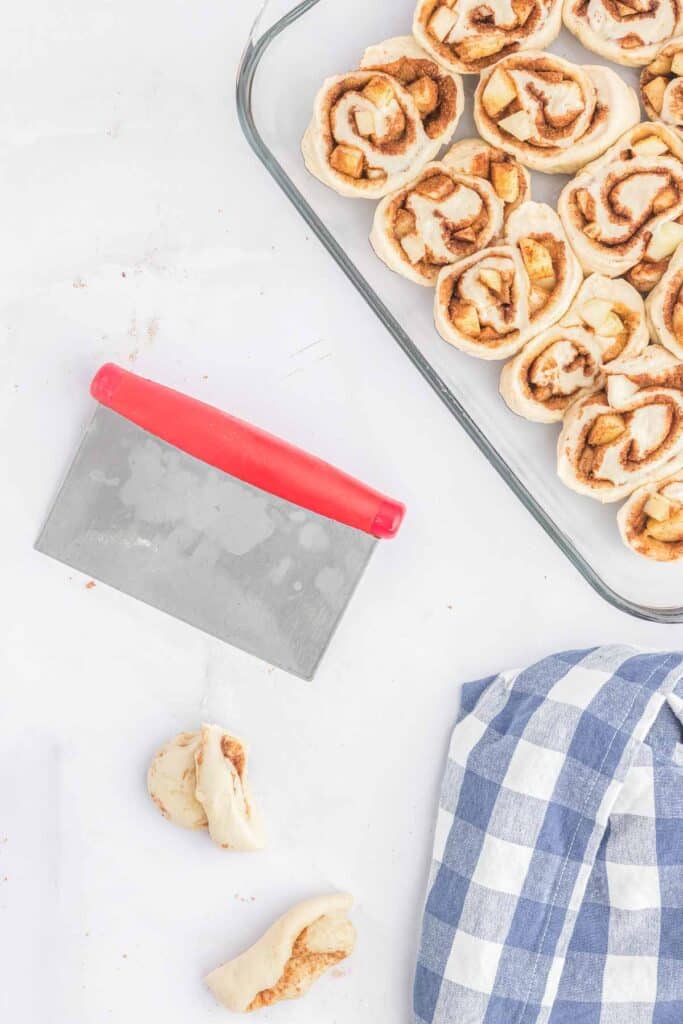 Apple cinnamon roll dough sliced and placed in a glass pan.