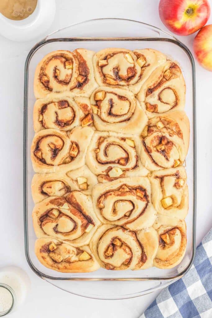A rectangular glass baking dish filled with apple baked cinnamon rolls.