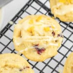Close-up of cranberry orange cookies recipe drizzle with a simple icing on a cooling rack.