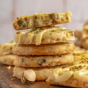 Stack of pistachio shortbread cookies with a bite taken out of the top one.