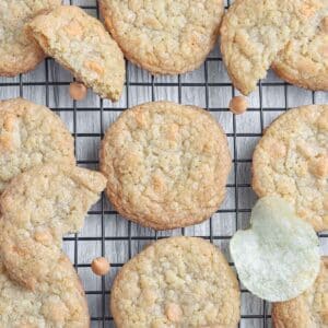 Potato chip cookies cooling on a wire rack with a few potato chips scattered between.