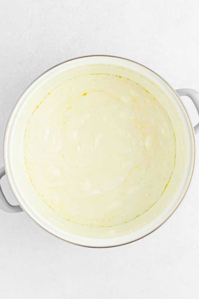 A large mixing bowl filled with melted mini marshmallows mixed in the melted butter.