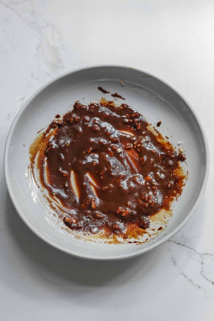 A white plate with miso paste, soy sauce, honey, rice vinegar, sesame oil, garlic, and ginger whisked together for a marinade.