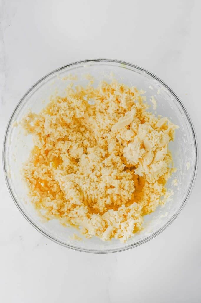 A glass bowl with the wet mixture added to the dry mixture incrementally.