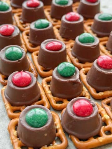 Rows of pretzels topped with m&ms and rolos.