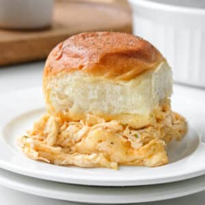 A buffalo chicken slider served on a soft bun, placed on a white plate.