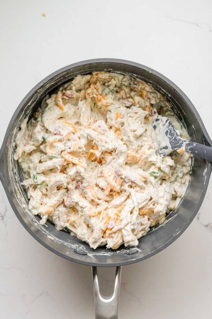 A saucepan filled with a creamy chicken filling mixture.