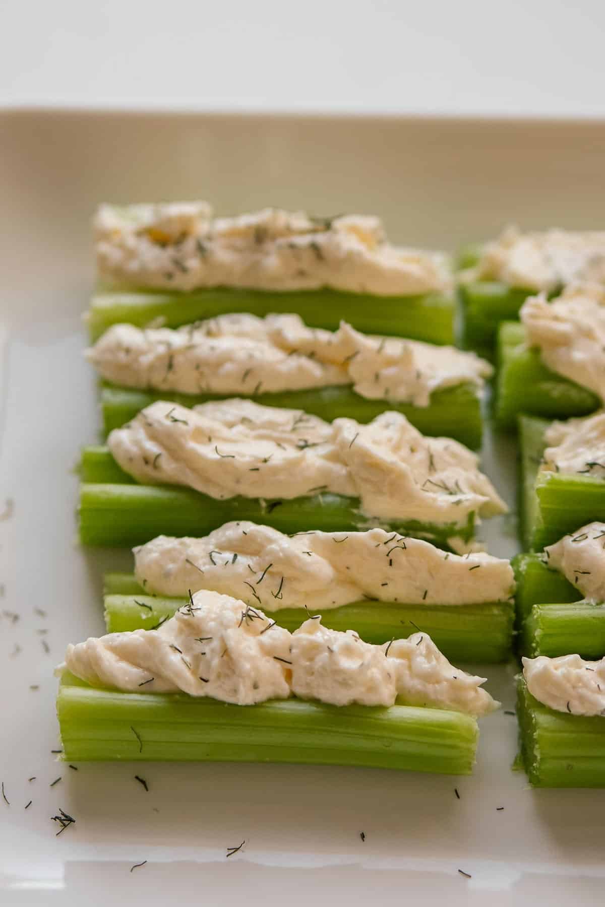 Stuffed Celery sticks arranged on a plate, each topped with a cream cheese mixture.