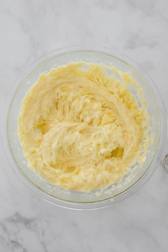 A glass bowl filled with smooth, creamy, whipped potatoes.