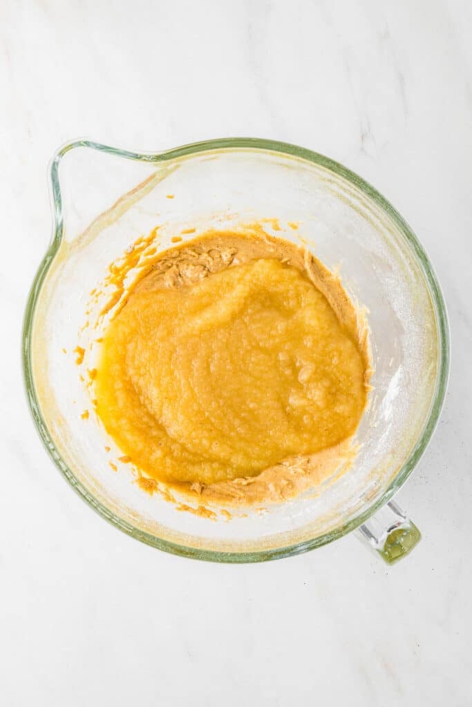 Applesauce Crumb Cake batter with applesauce added in a clear mixing bowl