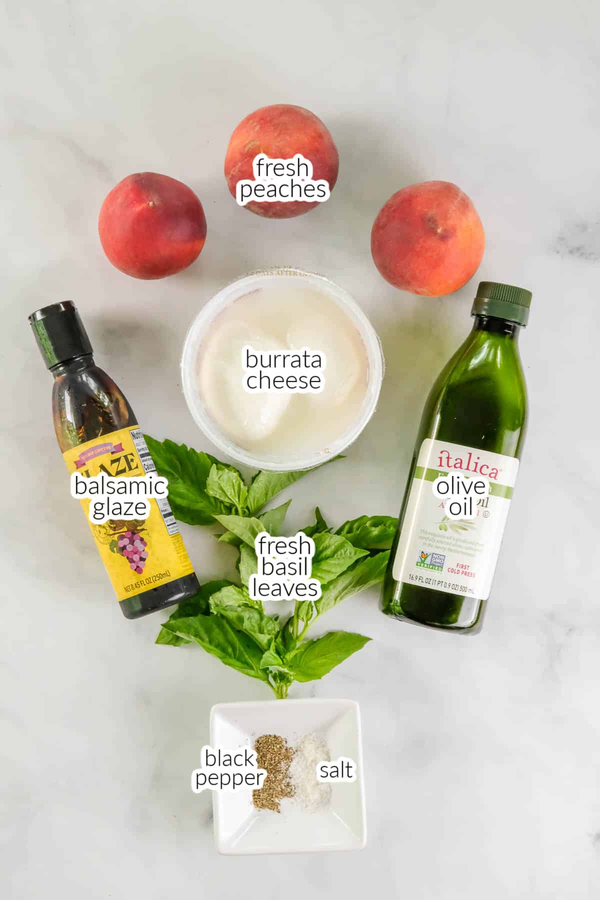 Ingredients for burrata peach salad laid out including burrata cheese, fresh peaches, balsamic glaze, olive oil, fresh basil leaves, salt, and black pepper on a white surface.