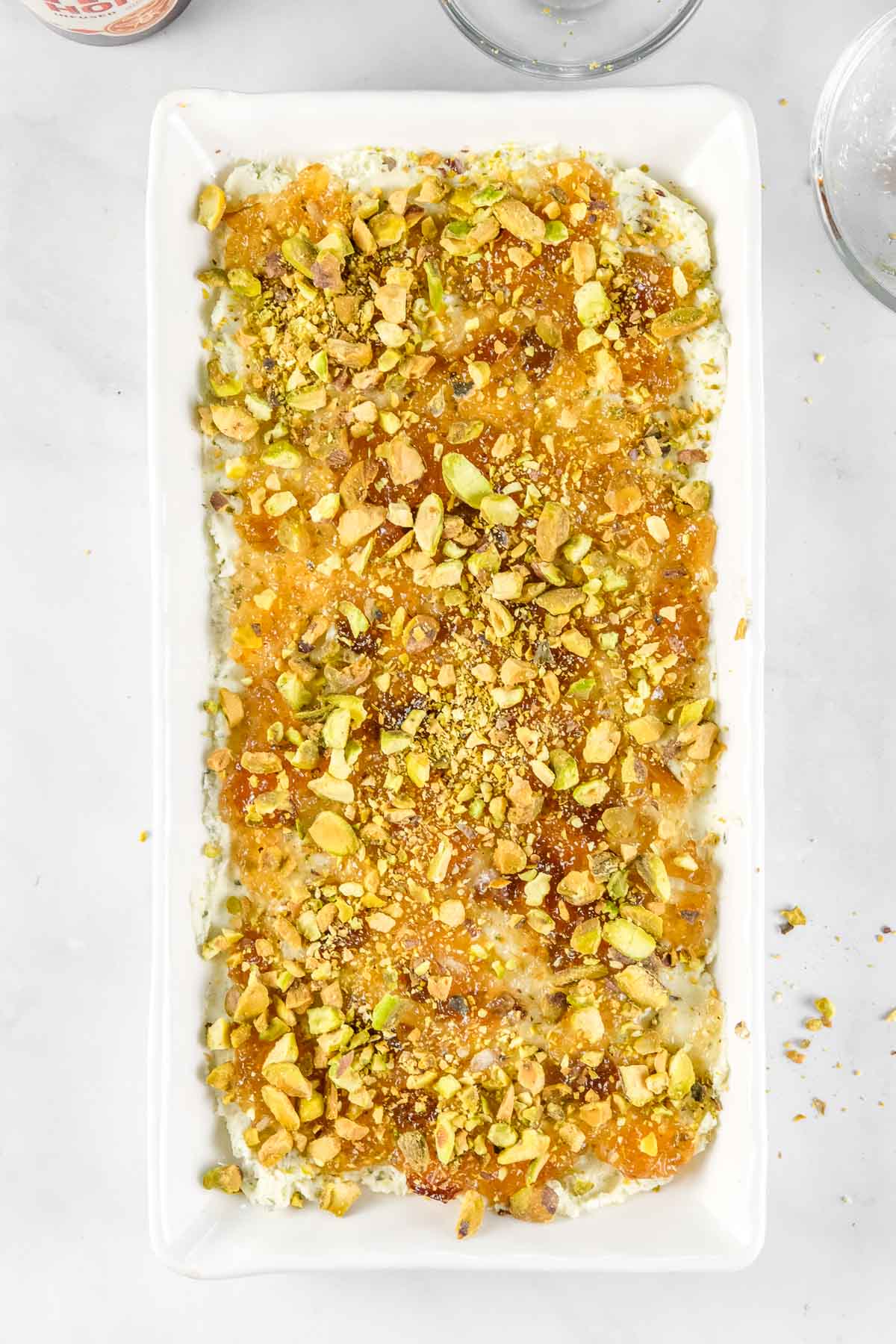 Rectangular white dish with boursin cheese spread, topped with pistachio.