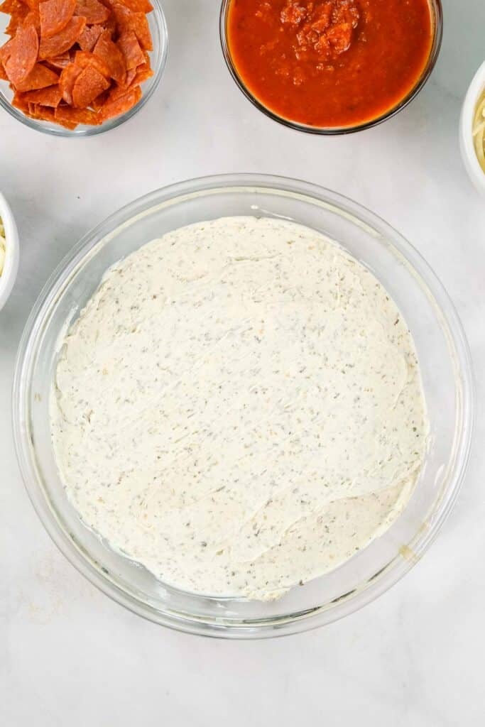 A glass bowl of seasoned cream cheese mix.